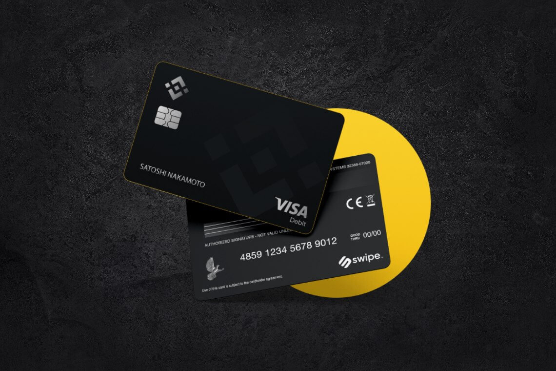 two black binance Visa cards in front of yellow circle